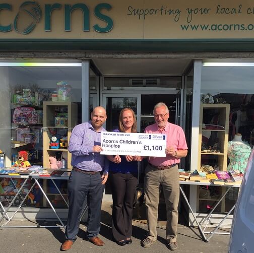 Acorns staff holding cheque 